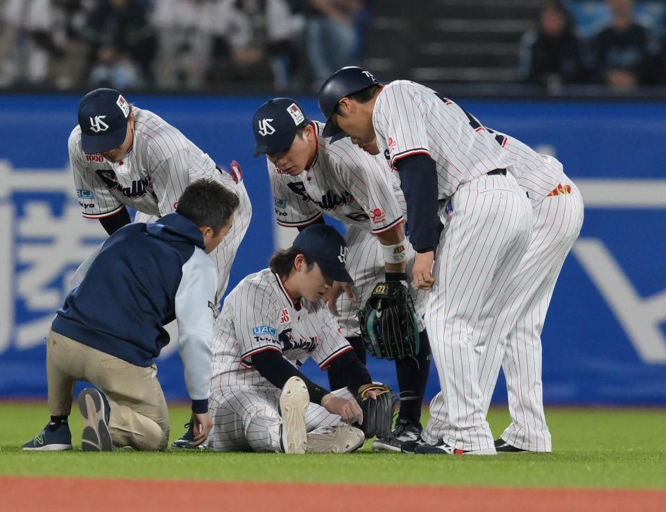 　８回、岡本の遊直を好捕するもその場に倒れ込んだ長岡（中央）にトレーナーらが駆けつける（撮影・伊藤笙子）