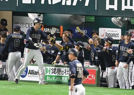 　１回、先制ソロを放ち、ベンチのナインとタッチを交わす広岡