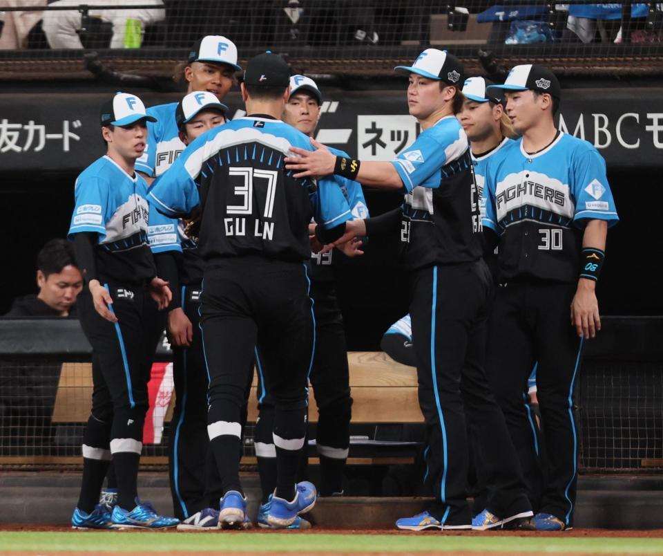 　６回途中７失点で降板し、ナインに迎えられる古林（中央）＝撮影・中島達哉