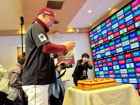 　デコレーションケーキを自らの携帯電話で記念に撮影する三木監督