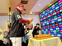 　デコレーションケーキを自らの携帯電話で記念に撮影する三木監督