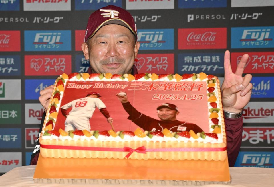 　誕生日ケーキを前に笑顔でポーズをとる三木監督