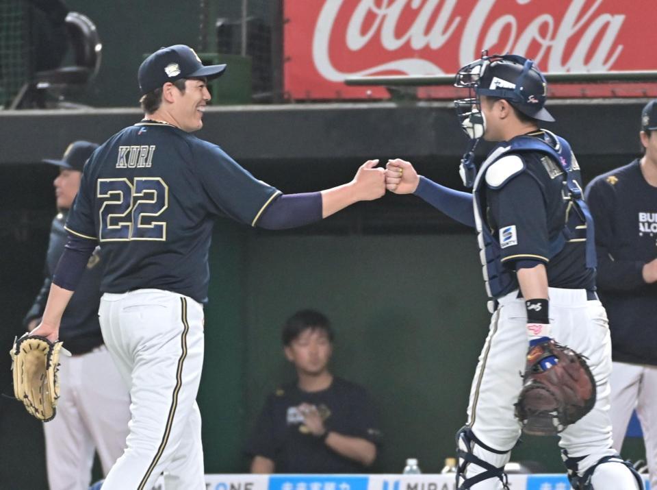 　４回、ピシャリと抑え、若月とグータッチを交わす九里（左）＝撮影・持木克友