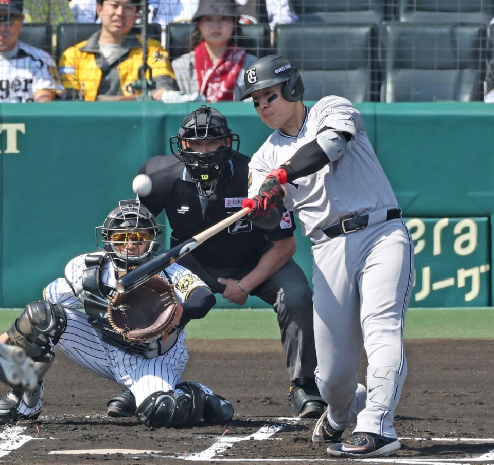 　１回、先制の中犠飛を放つ岡本（捕手は坂本）＝撮影・中田匡峻