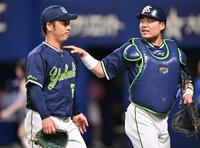 　５回を投げ終え、中村悠（右）とベンチに戻る小川