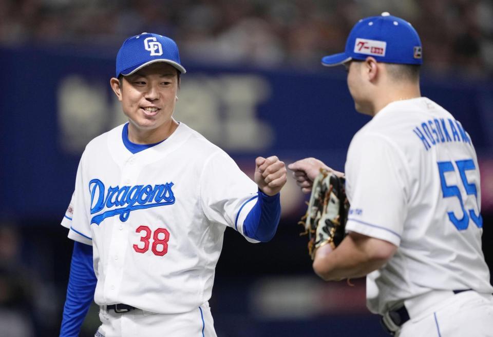 　８回を投げ終え、細川（右）とタッチを交わす松葉