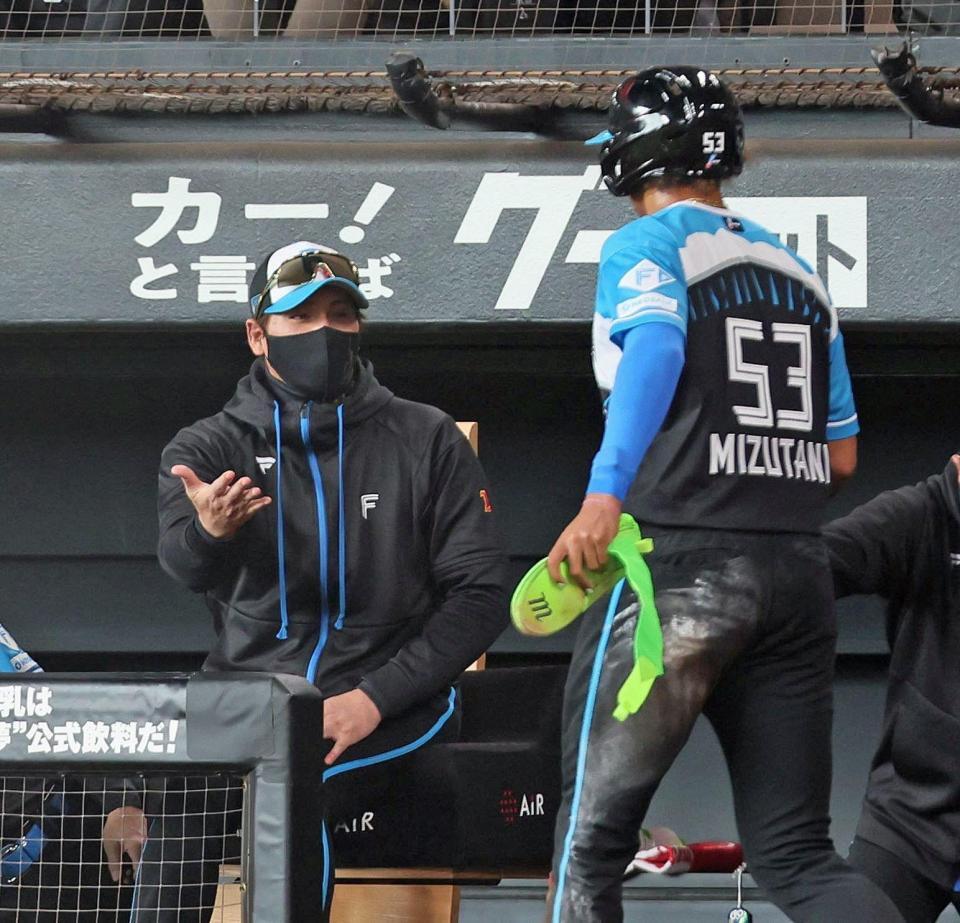 　１回、野村の適時打で生還した二走・水谷（右）を迎える新庄監督（撮影・中島達哉）