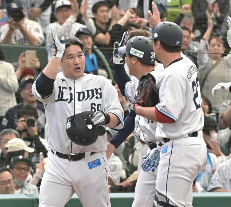 　代打でサヨナラ二塁打を放ち、ナインとタッチを交わす中村剛（左）＝撮影・持木克友