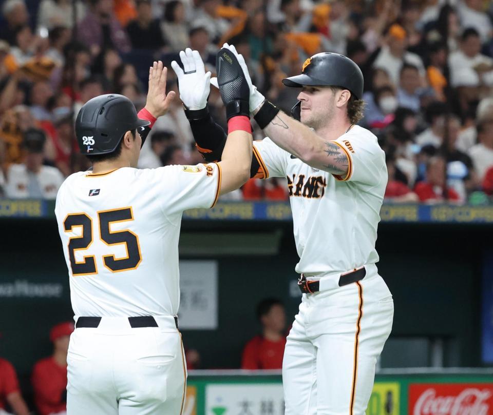 　２回、先制２ランを放ち一走岡本（左）とタッチを交わすキャベッジ