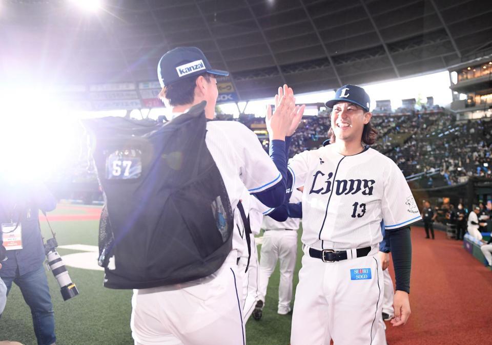　笑顔でナインとハイタッチする高橋（右）＝撮影・園田高夫