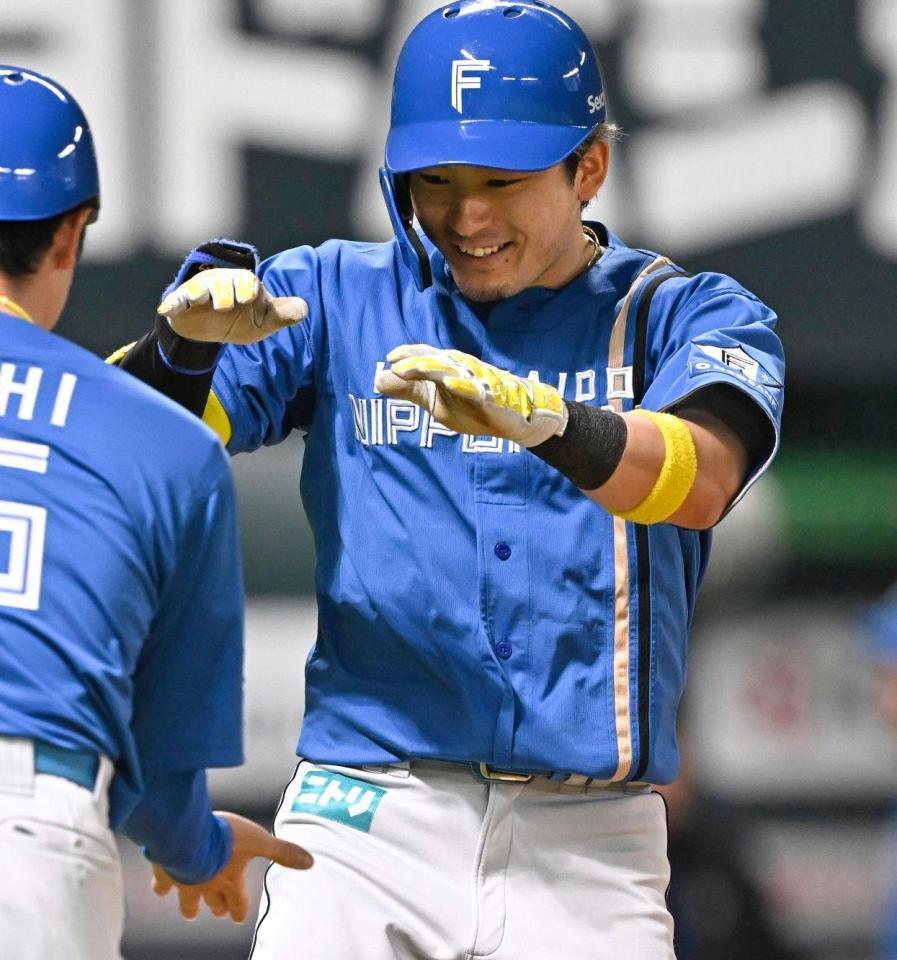 　１０回、決勝ソロを放ちコーチとタッチする水野