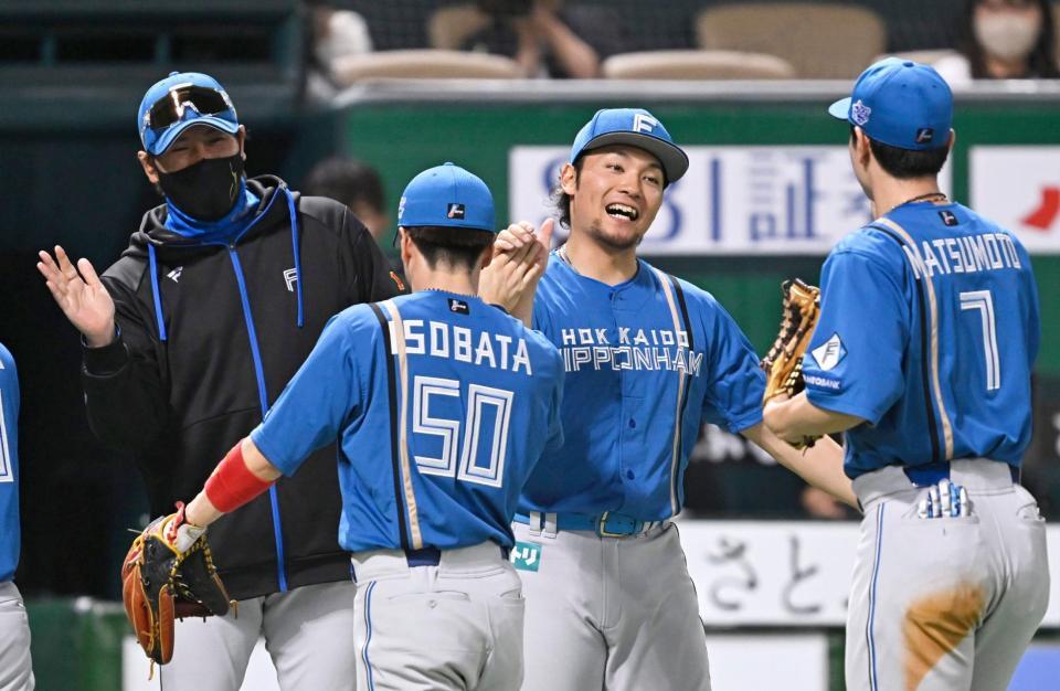 　９回１失点で３勝目を挙げナインを迎える伊藤（右から２人目）。左端は新庄監督