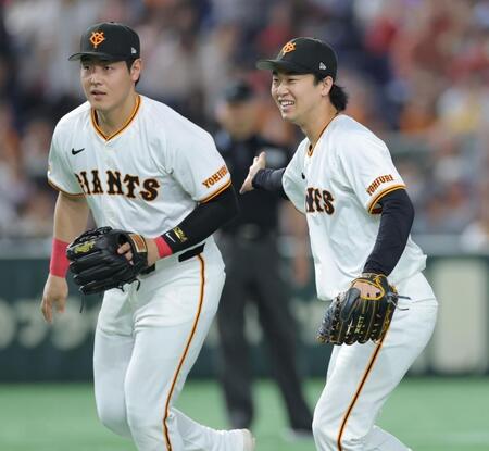 　開幕から２９イニング無失点の球団記録を更新し、岡本（左）と喜び合う山崎（撮影・西岡正）