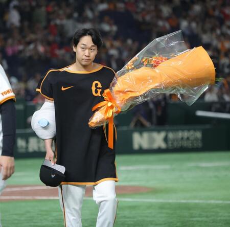 　開幕から３２イニング無失点のセ・リーグ記録を更新し、花束を持つ山崎（撮影・西岡正） 