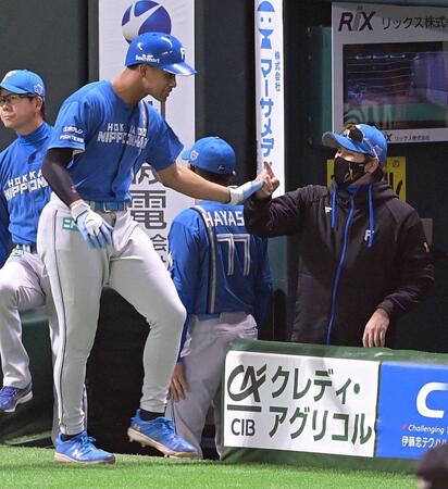 　４回、石井の右越え適時二塁打で生還した万波とタッチを交わす新庄監督（右）