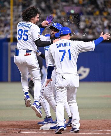 　１１回、サヨナラ犠飛を放ちロドリゲス（左）に祝福されるカリステ（中央）