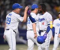 　１１回、サヨナラ犠飛を放ち、井上監督（左）とタッチを交わすカリステ
