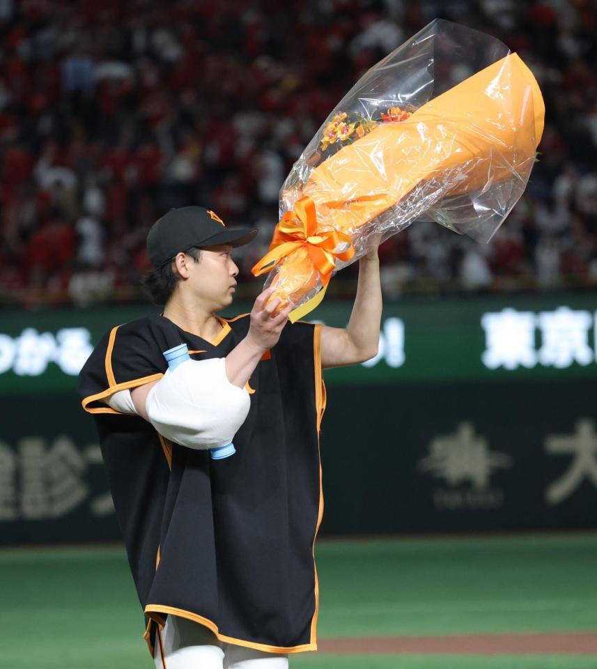 　花束を掲げる山崎（撮影・西岡正）