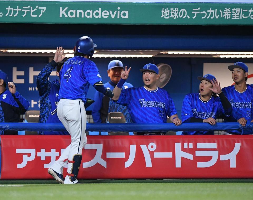 　４回、同点の中越えソロを放ちナインとタッチを交わす度会（手前）＝撮影・開出牧