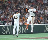 　６回、同点ソロをは放ち、ジャンプして松本コーチ（左）とタッチを交わすキャベッジ（撮影・西岡正）