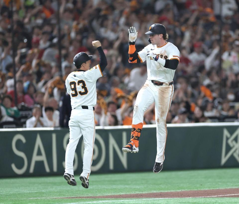 　６回、同点ソロをは放ち、ジャンプして松本コーチ（左）とタッチを交わすキャベッジ（撮影・西岡正）