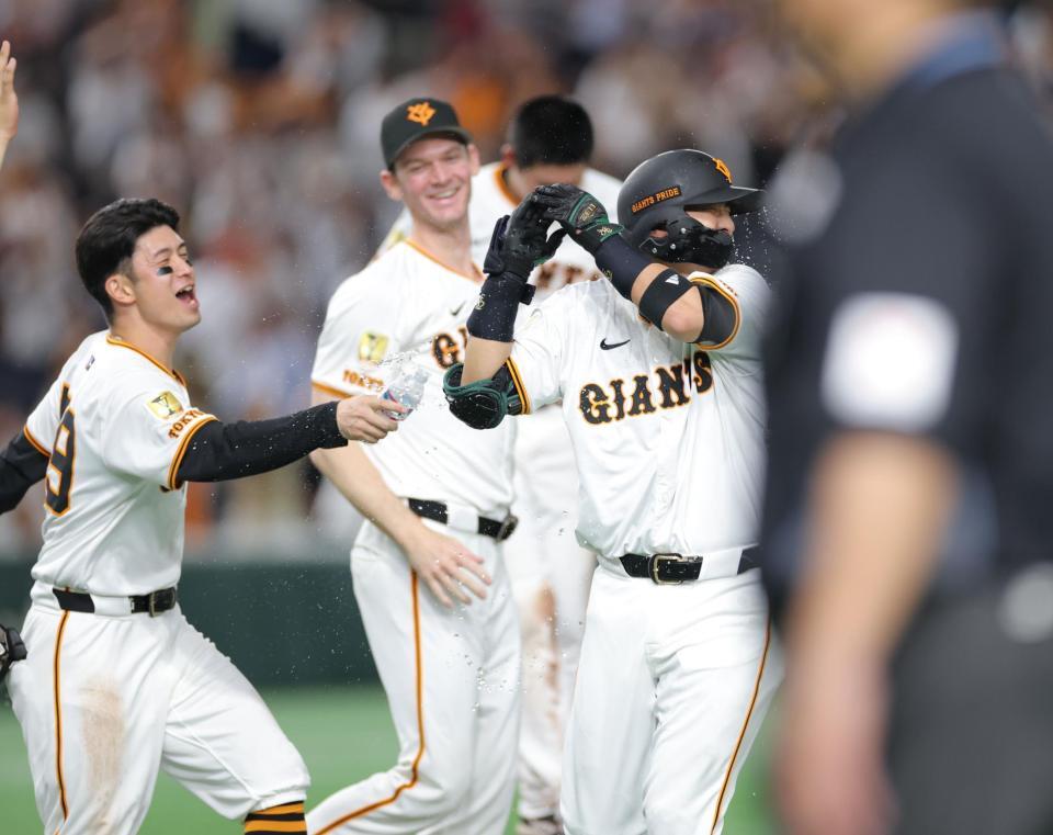 　１２回、サヨナラ打を放ち、水シャワーを浴びる吉川（右）＝撮影・西岡正