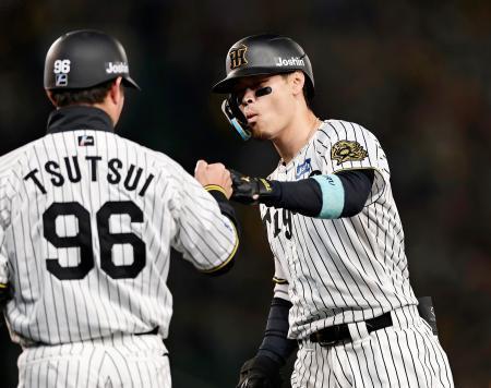 　６回、先制打を放ち、コーチとタッチを交わす阪神・佐藤輝＝甲子園