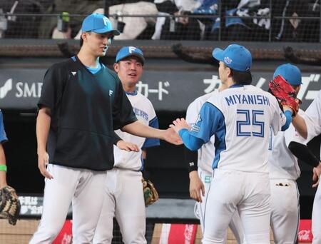 　７回、代打・平沼を抑えた宮西（右）を迎える達（撮影・中島達哉）