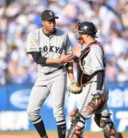 　最終回を抑えて岸田（右）と握手を交わすマルティネス（撮影・開出牧）