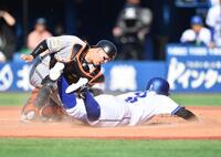 　５回、石上の投ゴロで三塁から滑り込む京田（手前）の生還をタッチアウトで阻止する岸田（撮影・開出牧）