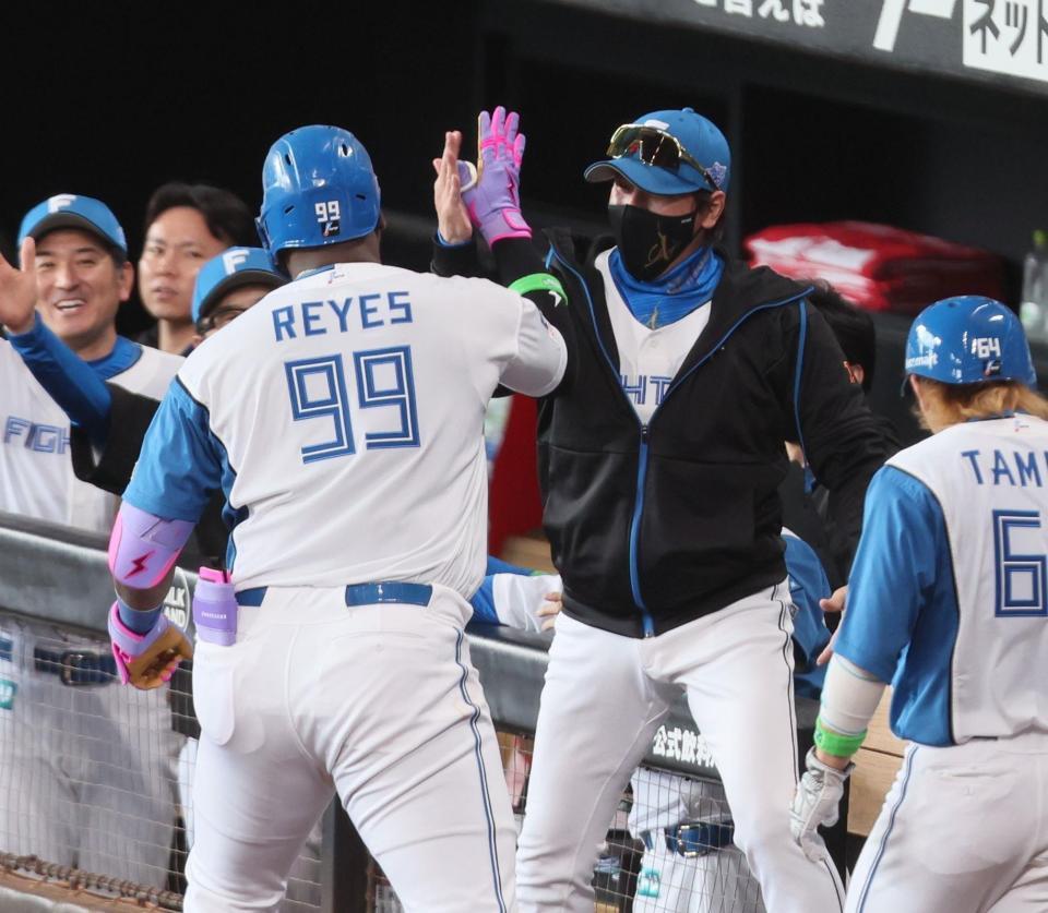 　１回、先制２ランを放ったレイエス（９９）とタッチを交わす新庄監督（中央右）＝撮影・中島達哉