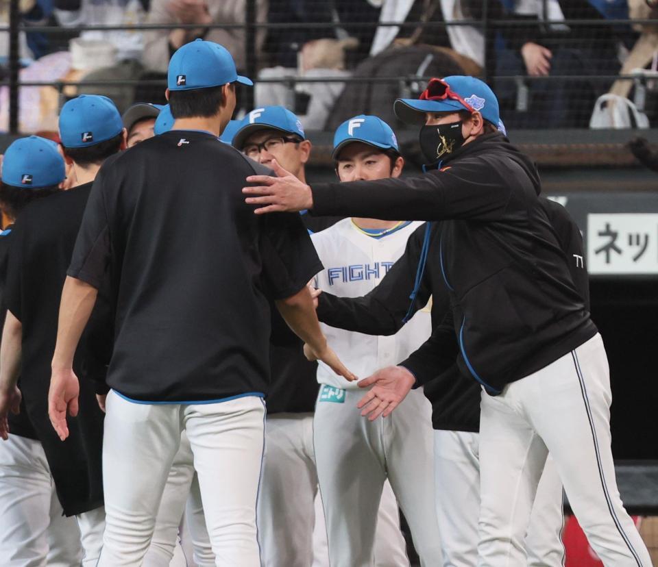 　今季初勝利をあげた達（左）らを迎える新庄監督（撮影・中島達哉）