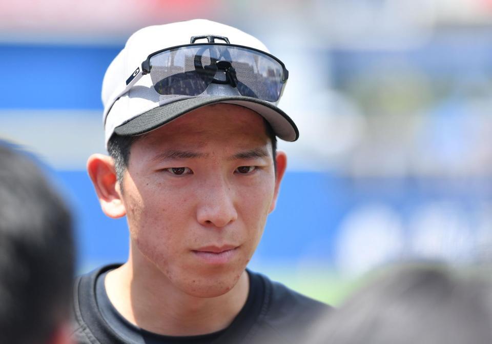 　試合前の練習を終え取材に応じる戸郷（撮影・開出牧）