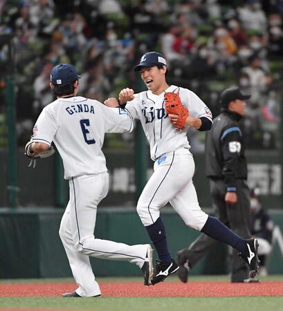 　安達の当たりで好守備を見せ、遊撃・源田（左）とグータッチする二塁手・山野辺＝２０２０年１０月