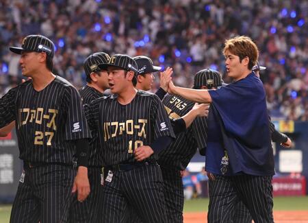 　勝利し、ナインとタッチする九里亜蓮（右）＝撮影・西田忠信