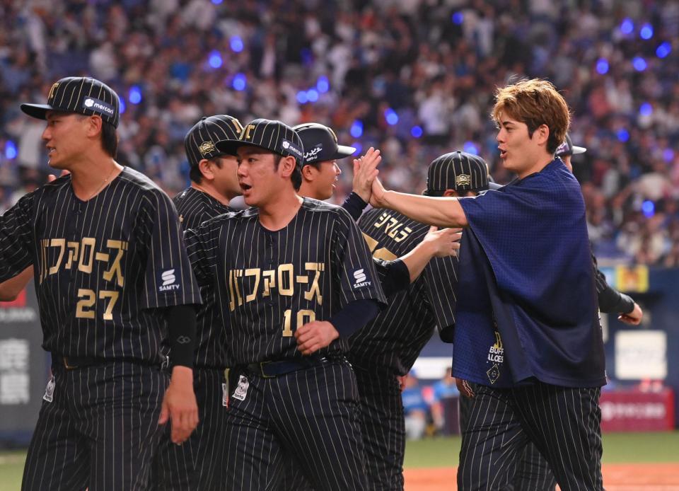 　勝利し、ナインとタッチする九里亜蓮（右）＝撮影・西田忠信