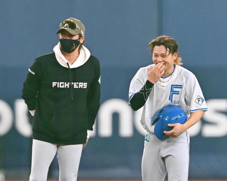 　田宮（右）に笑顔で話しかける新庄監督（撮影・西田忠信）