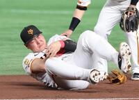 　１回、犠打を決めた中野と交錯、苦しそうに左腕を押さえる一塁手・岡本