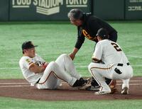 　１回、犠打の中野と送球を受けた際に交錯し左腕を痛めた岡本（撮影・金田祐二）