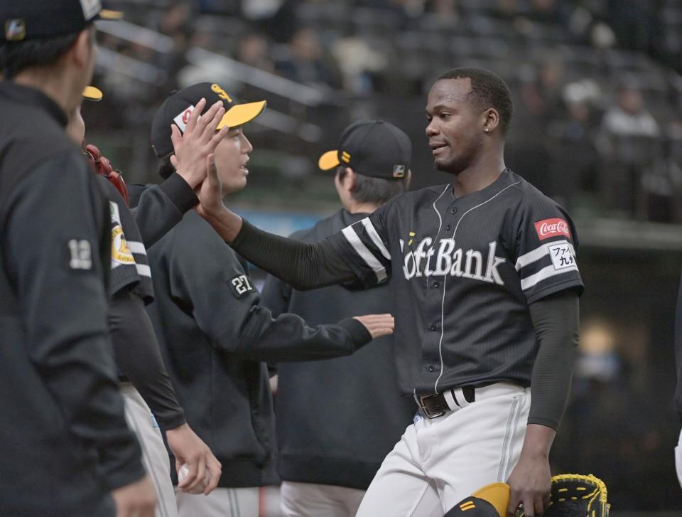 　５回まで西武打線を１安打に抑えナインに出迎えられるモイネロ（撮影・持木克友）