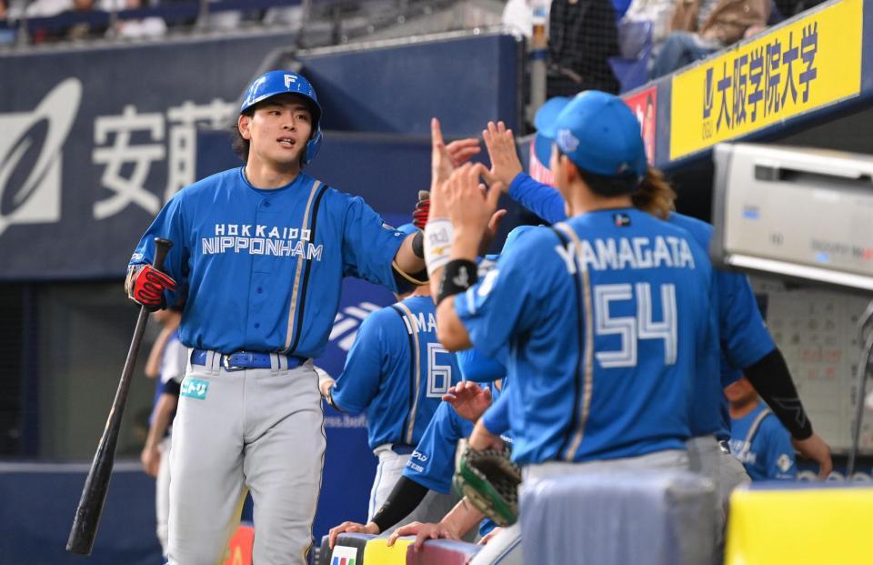 　９回、左中間ソロを放ちナインとタッチする野村（左）＝撮影・西田忠信