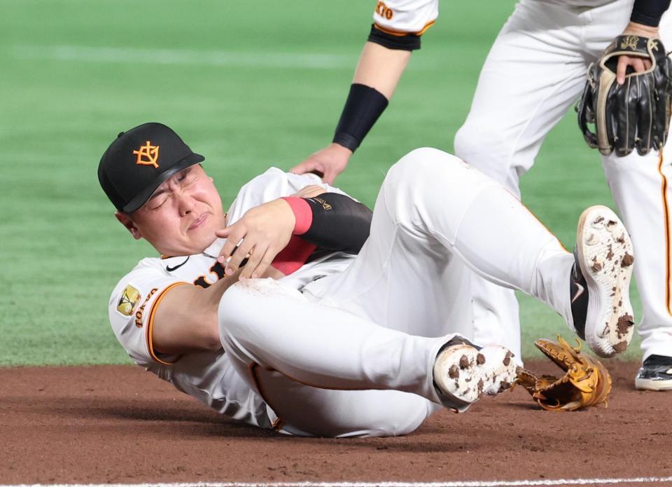 　１回、犠打を決めた中野と交錯、苦しそうに左腕を押さえる一塁手・岡本