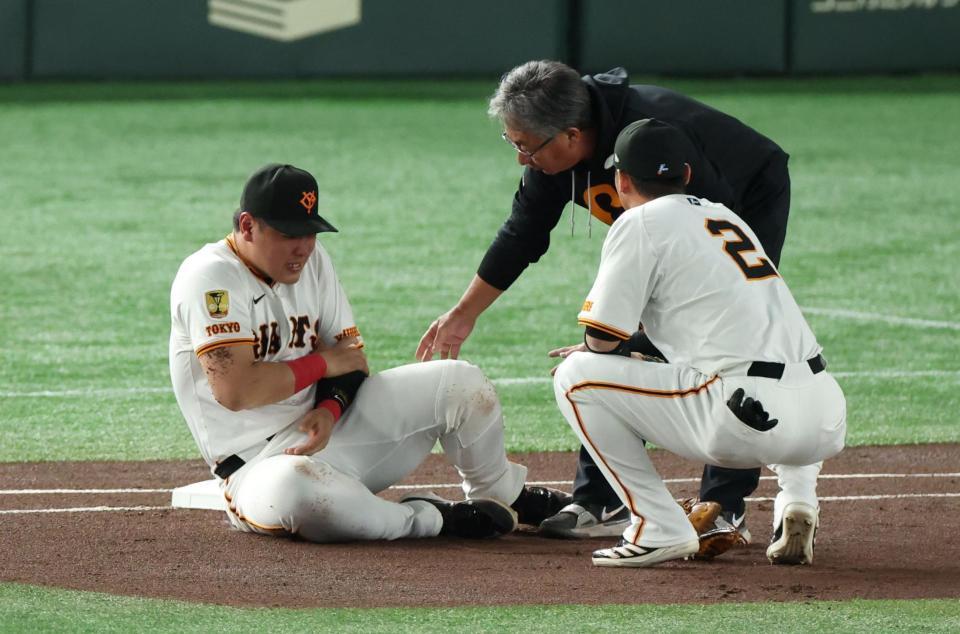 　１回、犠打の中野と送球を受けた際に交錯し左腕を痛めた岡本（撮影・金田祐二）