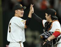 　チームの勝利に貢献した坂本（左）は甲斐とタッチを交わす（撮影・田中太一）