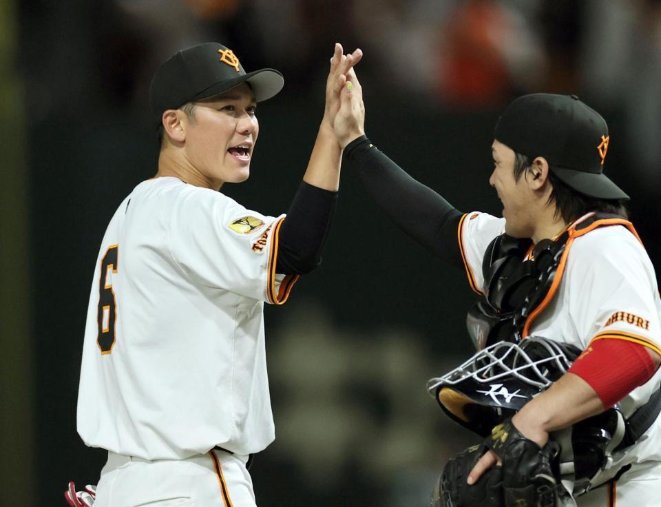 　チームの勝利に貢献した坂本（左）は甲斐とタッチを交わす（撮影・田中太一）