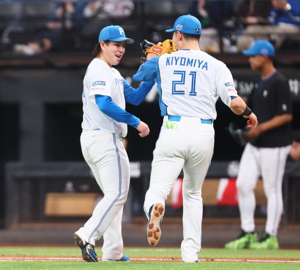 ８回、ピンチを最小失点でしのぎ、清宮幸（右）とタッチを交わす金村（撮影・中島達哉）