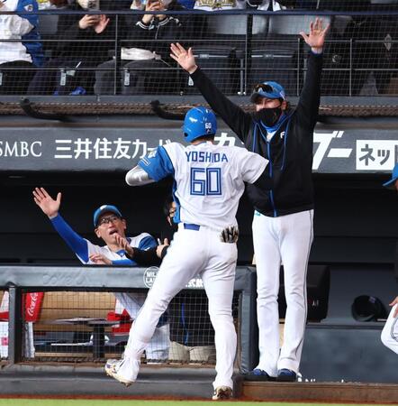 　１回、先頭打者本塁打を放った吉田（６０）をハイタッチで迎える新庄監督（右）＝撮影・中島達哉