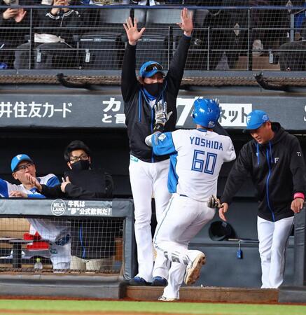 　１回、先頭打者本塁打を放った吉田（６０）をハイタッチで迎える新庄監督（中央）＝撮影・中島達哉