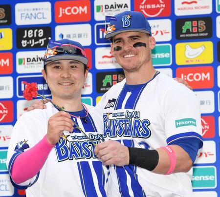 　カーネーションを手ににっこりのオースティン（右）と佐野（撮影・佐藤厚）