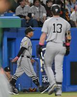 　９回、キャベッジ（手前）が空振り三振に倒れて試合終了となり、足早にベンチを後にする阿部監督（撮影・伊藤笙子）